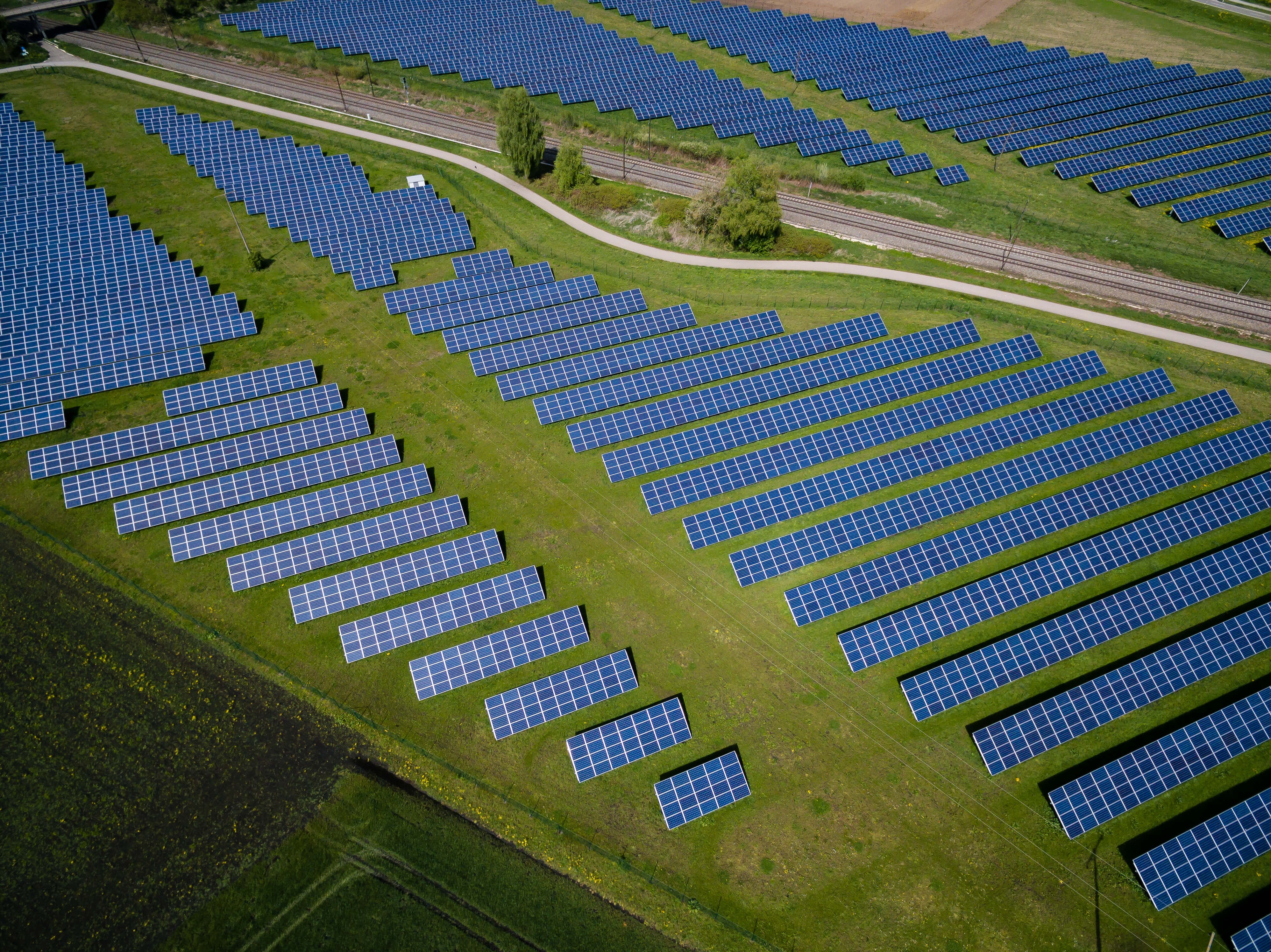 Solar panels arranged across a green landscape